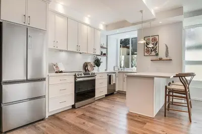 a large kitchen with white cabinets and a counter top at Modern 2BR Oasis with BBQ Sauna & Private Yard in Los Angeles