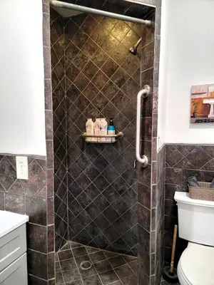 a bathroom with a shower with brown tiles at Two bedroom private guesthouse in great location Close to Melrose Hollywood sign and attractions in Los Angeles