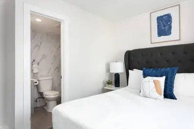 a bedroom with a white bed and a toilet at Central 3BR Apt Near Americana in Glendale