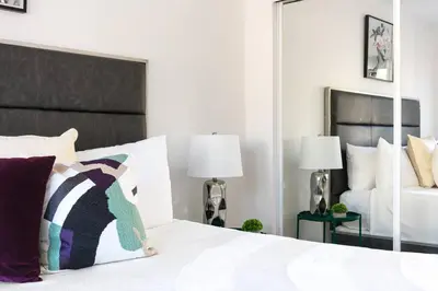 a bedroom with a white bed with pillows and a mirror at Central 3BR Apt Near Americana in Glendale