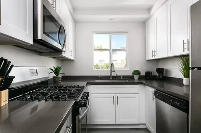 a kitchen with white cabinets and a stove top oven at Central 3BR Apt Near Americana in Glendale