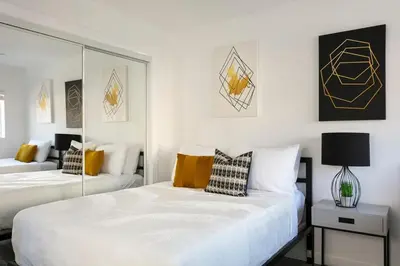 a bedroom with two beds and a mirror at Enjoy Stylish 4BR Townhouse Sleeps 8 with Wi-Fi in Los Angeles