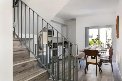 a kitchen and dining room with a staircase and a table at Enjoy Stylish 4BR Townhouse Sleeps 8 with Wi-Fi in Los Angeles