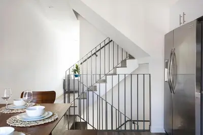 a dining room with a table and a staircase at Enjoy Stylish 4BR Townhouse Sleeps 8 with Wi-Fi in Los Angeles