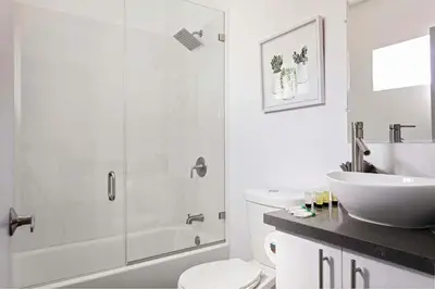 a bathroom with a shower and a toilet and a sink at Experience Luxury 4BR Townhouse Sleeps 8 with Parking in Los Angeles