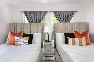 two beds with colorful pillows in a bedroom at Luxury 2BR Apartment Great Area with Parking in Glendale