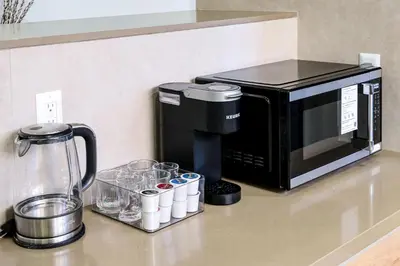 a kitchen counter with a coffee maker and a microwave at Modern LA Villa 5BR Home with Private Pool & Yard in Los Angeles