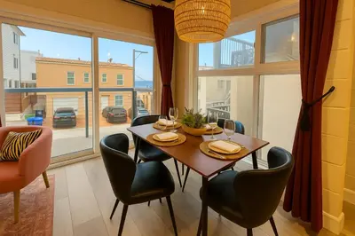 a dining room with a table and chairs and a large window at Ocean View Balcony, 4 Min Walk to Beach in Manhattan Beach