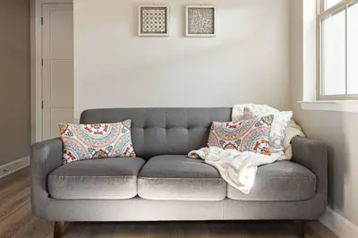 a gray couch in a living room with pillows at The Reel Deal, Luxury Family Cabin by Alpine Slide in Big Bear Lake