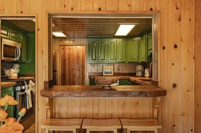 a kitchen with green cabinets and a counter at Lakeside Lodge - Deck Views, Golf, Basketball, Spa in Fawnskin