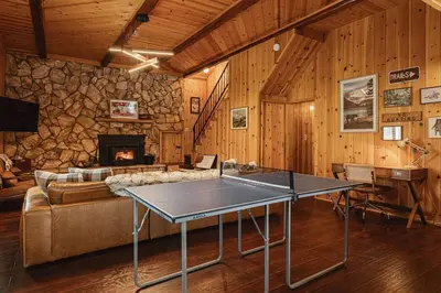 a table in a living room with a couch and a fireplace at Lakeside Lodge - Deck Views, Golf, Basketball, Spa in Fawnskin