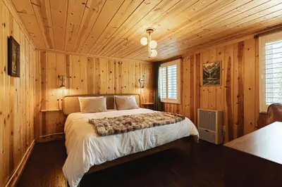 a bedroom with a bed in a wooden room at Lakeside Lodge - Deck Views, Golf, Basketball, Spa in Fawnskin