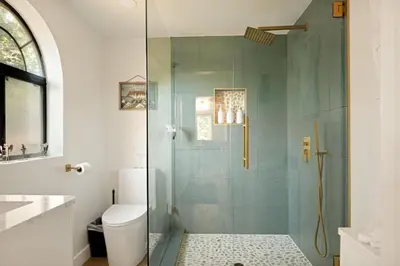 a bathroom with a glass shower with a toilet at Acorn Cottage in Big Bear Lake