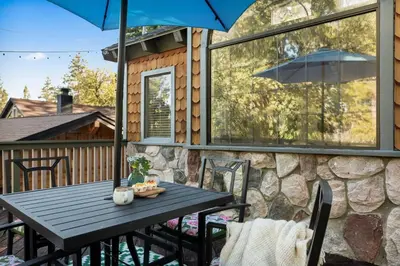 a table and chairs on a patio with an umbrella at Acorn Cottage in Big Bear Lake