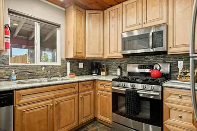 a kitchen with wooden cabinets and a stove top oven at Lawliss Hideout in Big Bear Lake in Big Bear Lake