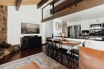 a kitchen and living room with a table and chairs at Solace Cabin in Big Bear Lake