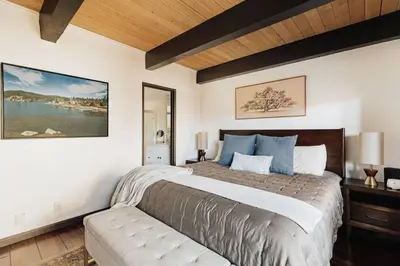 a bedroom with a large bed with blue pillows at Solace Cabin in Big Bear Lake