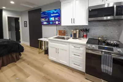 a kitchen with white cabinets and a sink and a stove at Walk to Hollywood Blvd Chic LA Studio with Patio! in Los Angeles