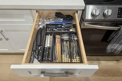 a wooden drawer filled with cooking utensils in a kitchen at Walk to Hollywood Blvd Chic LA Studio with Patio! in Los Angeles