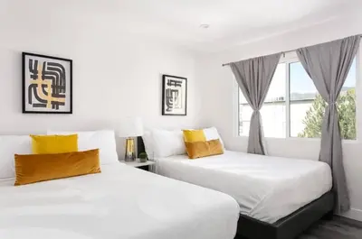 two white beds in a room with a window at Luxury 3BR Condo Near Americana and Galleria in Glendale