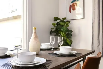 a dining room table with plates and wine glasses at Relax in Spacious 3BR Apt Sleeps 8 and Parking in Glendale