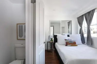 a white bedroom with a white bed and a window at Enjoy Stylish 3BR Apt Sleeps 6 with Free Parking in Glendale