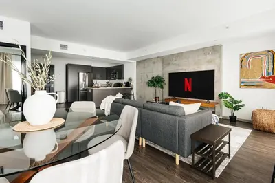 a living room with a gray couch and a tv at Luxury Spacious Studio in Los Angeles