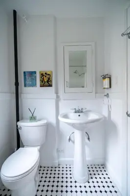 a white bathroom with a toilet and a sink at Furnished Studio in Hollywood in Los Angeles