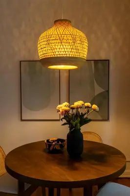 a table with a vase of flowers and a lamp at Furnished Studio in Hollywood in Los Angeles