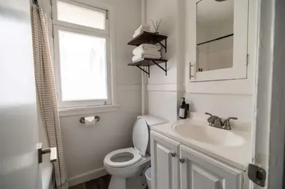 a bathroom with a toilet and a sink and a window at Cozy Studio in Hollywood in Los Angeles