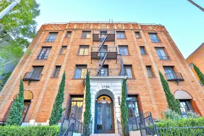 a red brick building with a door and balcony at Cozy Studio in Hollywood in Los Angeles