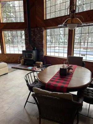 a living room with a wooden table and chairs at Little Bear Lodge in Springville
