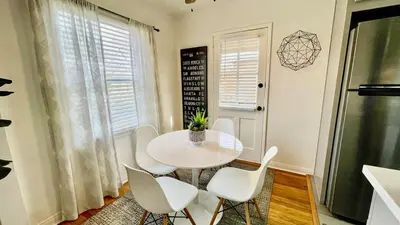 a white dining room with a white table and chairs at Remodeled Bixby Knolls 2 bedroom unit - Close to shopping in Long Beach