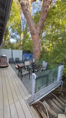 a deck with tables and chairs and a tree at Joyful Place in Sherman Oaks