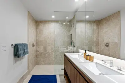 a bathroom with a white sink and a shower at Pearl Coast - Modern 2BR with Rooftop Pool & Views in Los Angeles
