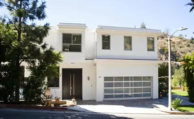 a white house with a garage at Hollywood Hills Luxury Mansion with Pool & Views in Los Angeles