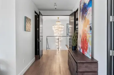 a hallway with white walls and a large painting on the wall at Hollywood Hills Luxury Mansion with Pool & Views in Los Angeles