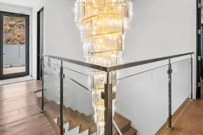 a staircase in a house with a chandelier at Hollywood Hills Luxury Mansion with Pool & Views in Los Angeles