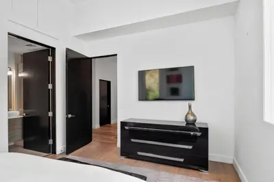 a bedroom with white walls and a black dresser at Hollywood Hills Luxury Mansion with Pool & Views in Los Angeles