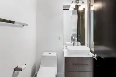 a bathroom with a white toilet and a sink at Hollywood Hills Luxury Mansion with Pool & Views in Los Angeles