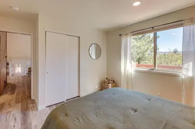 a bedroom with a large bed and a large window at Deck and Views Modern Cabin Near Lake Arrowhead! in Lake Arrowhead