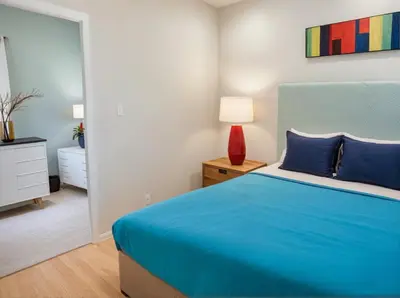 a bedroom with a blue bed and a lamp at Stay in Style Hollywood Residences with Free Parking in Los Angeles