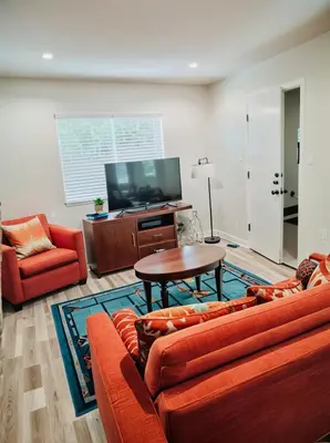 a living room with a couch and a table and a tv at Stay in Style Hollywood Residences with Free Parking in Los Angeles