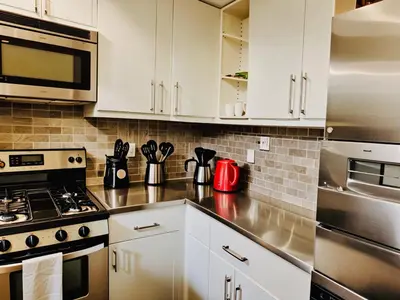 a kitchen with white cabinets and stainless steel appliances at Stylish Venice Escape Near the Marina & Beachfront in Los Angeles