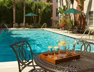 a table with drinks on it next to a swimming pool at Stylish Venice Escape Near the Marina & Beachfront in Los Angeles