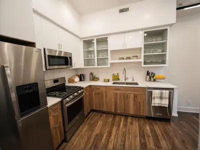 a kitchen with stainless steel appliances and wooden cabinets at Stylish Venice Escape Near the Marina & Beachfront in Los Angeles