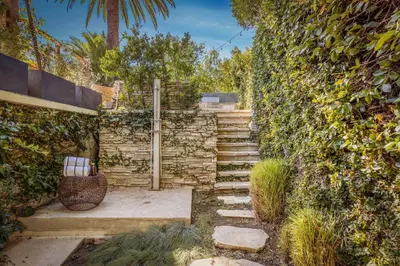 a stone wall with stairs next to a fence at Chateau Lumier by Stay Awhile in Los Angeles