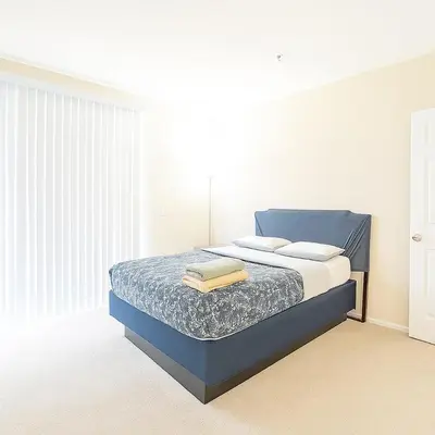 a bedroom with a blue bed in a white room at Cozy Home Close to Disney in Orange
