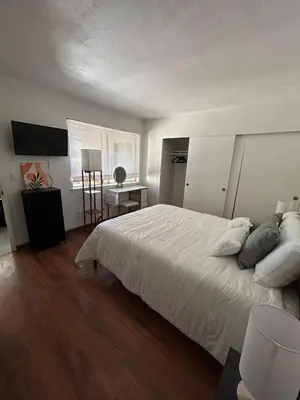 a bedroom with a white bed and a desk at Spacious Fully Furnished 3BR Fully Fenced Home in Riverside