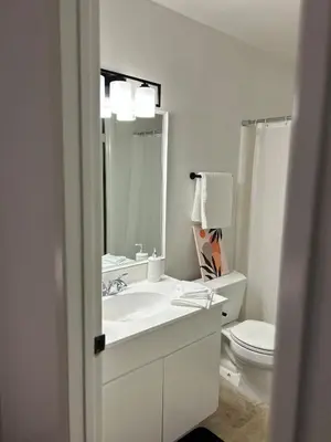 a white bathroom with a sink and a toilet at Spacious Fully Furnished 3BR Fully Fenced Home in Riverside
